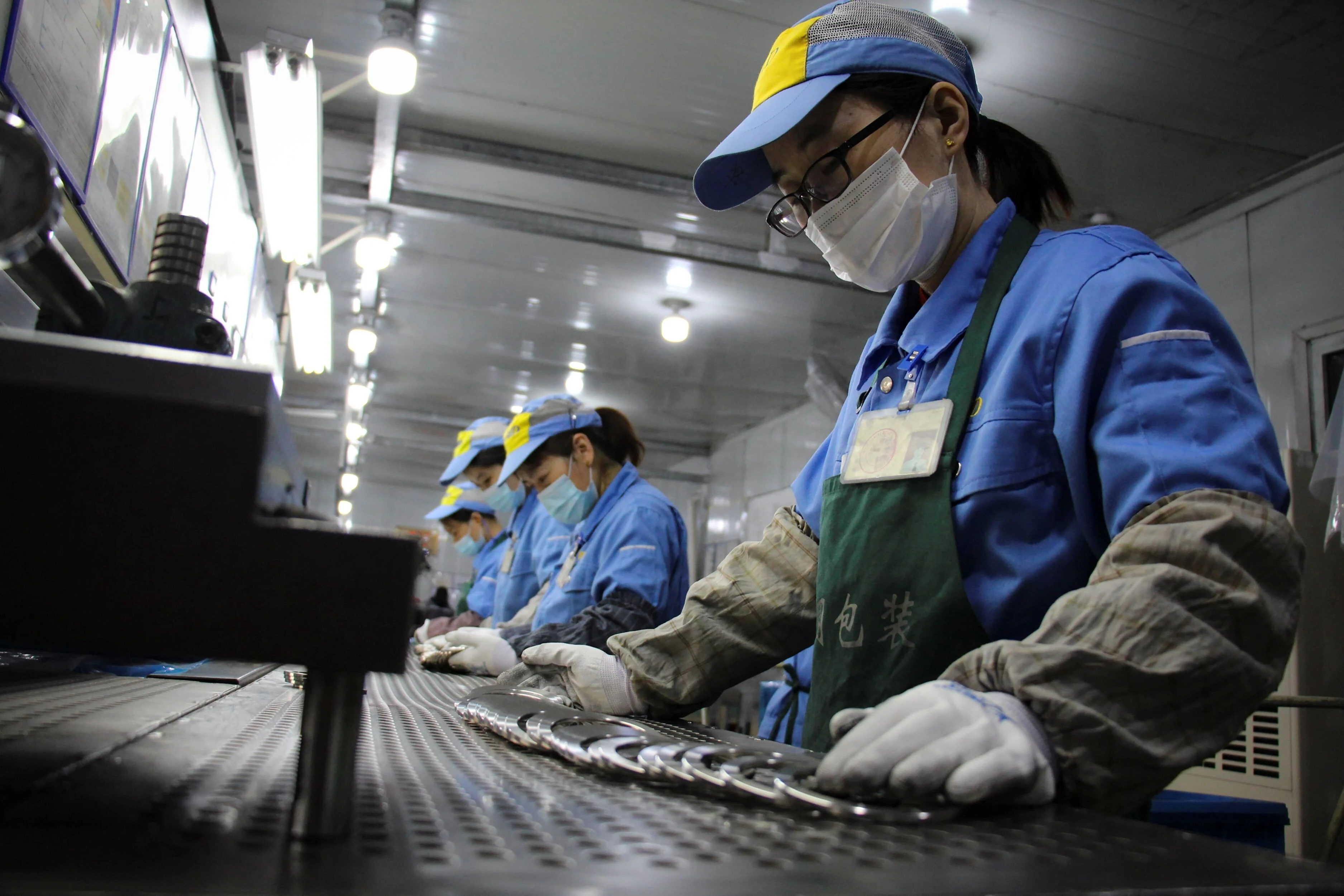 Chinese factory workers in a bustling manufacturing plant amid export growth